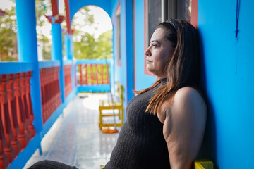 Latin woman relaxing on a porch enjoying summer breeze