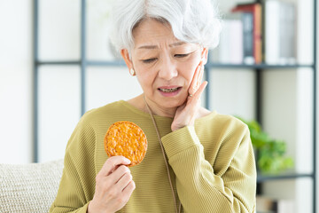 せんべいを食べるシニアの女性