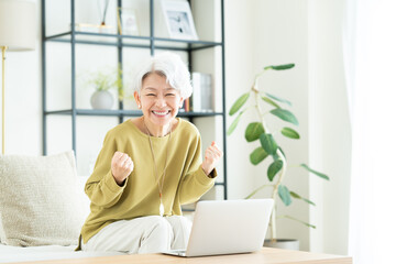 リビングでパソコンを使うシニアの女性