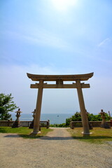 輝く太陽と海を望む鳥居