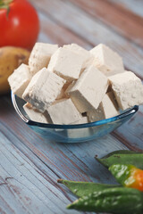 Fresh tofu cubes served with colorful vegetables on wooden table
