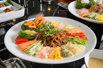 Noodles with shrimps and vegetables on a white plate