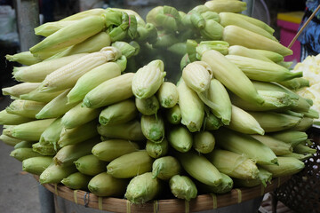 Steamed corn on a charcoal stove.
