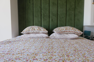 Cozy bedroom with floral bedding and green accent wall