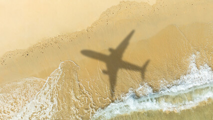 Aerial view of shadow passenger plane silhouette and sandy beach blue sea with waves at sea beach summer vacation sea travel concept	