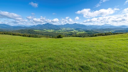 Fototapeta premium Panoramic mountain view from grassy hilltop, perfect for nature travel postcard