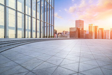Fototapeta premium Empty square floor and modern city buildings scenery at sunset