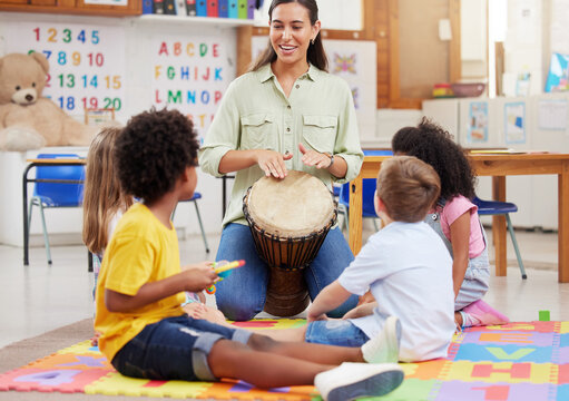 Teacher, kids and play drums in classroom for creative learning, language development and childhood. Woman, children and instruments for teaching music, sensory education and group activity at school - Powered by Adobe