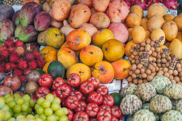 assortment of fresh Asian exotic tropical fruits on the counter at the Asian street market in Thailand
