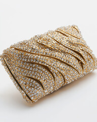 Close up of a bejeweled clutch. The purse is cream-colored with ornate, gold leaf and sparkling stone designs.