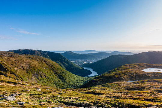 Mountaintop view from Mount Ulriken facing a valley leading to Bergen, Norway from the Vidden hiking trail at sunset