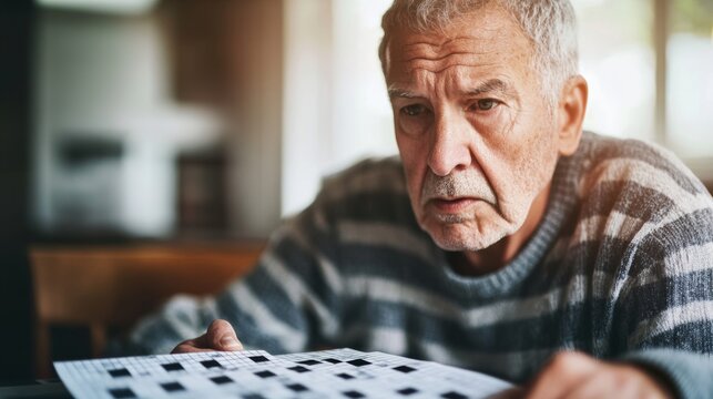 A senior with a distant look, sitting at a table with a crossword puzzle. Featuring cognitive challenges and frustration