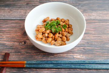 木製テーブルの上に置いた納豆と箸