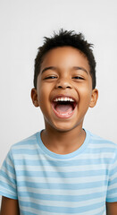 Naklejka premium Young boy with medium brown skin and spiky hair, wearing a striped T-shirt pastel blue, laughing while set against a clean white studio background.
