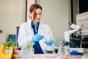 Scientist testing food samples in lab with microscope, vegetables, and meat for safety, nutrition,...