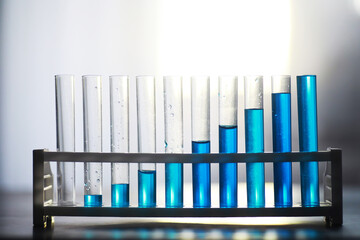 Obraz premium Test tube with blue liquid on the laboratory table. Examination of liquid under a microscope.