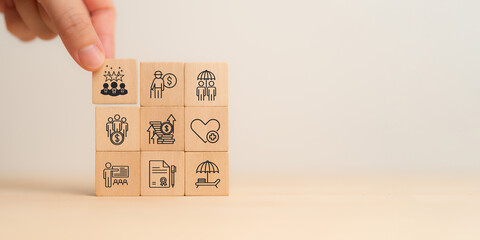 Employee benefits concept. A hand placing wooden blocks with icons representing various employee...