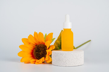 Plastic white tube for cream or lotion. Skin care or sunscreen cosmetic with fake flowers on white background.