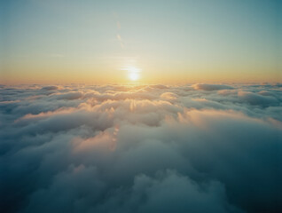 Serene sunrise above cloudscape with golden horizon for inspirational posters and nature designs