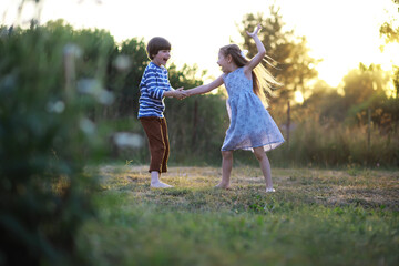 Fototapeta premium Children walk in the summer in nature. Child on a sunny spring morning in the park. Traveling with children.