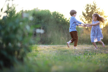 Naklejka premium Children walk in the summer in nature. Child on a sunny spring morning in the park. Traveling with children.
