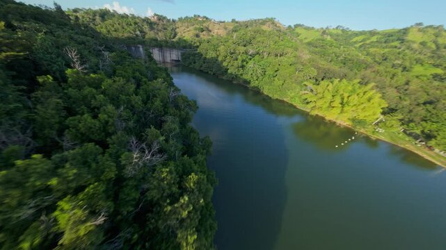 Hatillo Dam, concrete structure surrounded by lush greenery, Cotui in Dominican Republic Drone flying under bulkheads, Aerial FPV