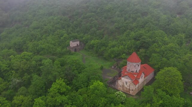 4K aerial drone footage of Vahanavank Monastery near Kapan, on the slopes of Mount Khustup in Syunik (Zangezur), Armenia. A historic medieval monastery surrounded by lush green forests and wild nature