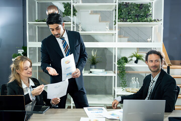 Business team reviewing financial charts in a modern office during corporate meeting. Professional colleagues discussing business growth strategies and analyzing reports in a collaborative environment