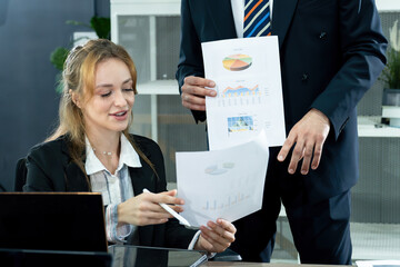 Smiling businesswoman reviewing financial reports during a corporate meeting in a modern office. Professional team discussing business strategies and economic growth in a collaborative setting.