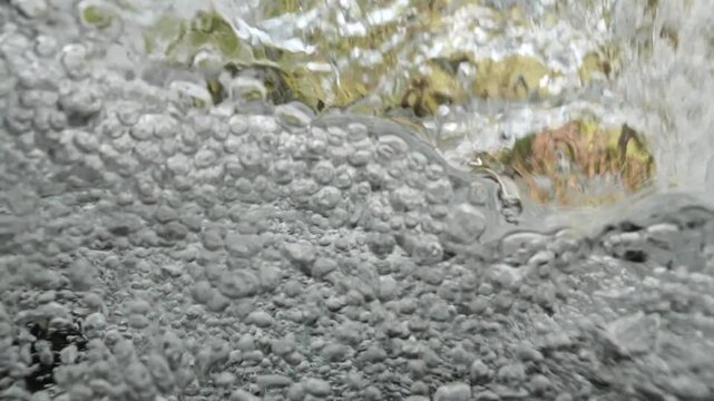 bubbles underwater makes shapes in fast flowing river fresh water