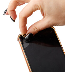 A hand is holding a cell phone with a cracked screen