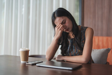 Young asian businesswoman is suffering from headache, feeling tired, exhausted and stressed while...