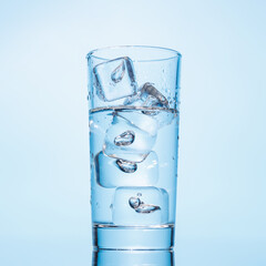 A clear glass filled with chilled water and ice cubes, creating a refreshing and cool drink