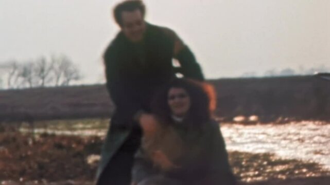 Happy loving couple young parents having fun in autumn nature. Funny man fooling around, hugging woman. Mother, father of newborn baby in stroller enjoy relaxing. Vintage film. Family retro archive