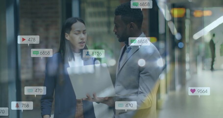 Image of social media notifications over diverse colleagues using laptop and talking