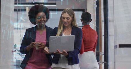 Image of financial data processing over diverse businesswomen using laptop