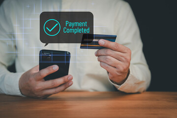 Person completing online payment using a credit card on mobile phone, with a glowing check mark and...