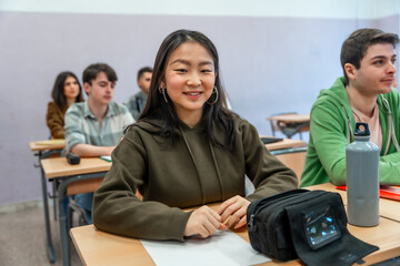 Smiling asian student attending a university lesson
