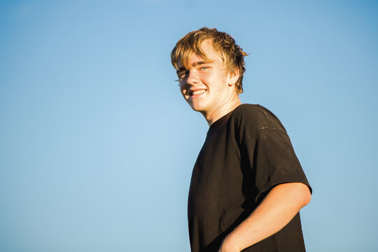 Portrait of teenage boy isolated on blue sky background