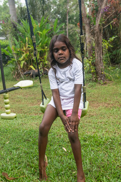 Sad 4 yo aboriginal child holding sore knee in hand