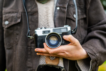 Photographer is holding a vintage camera outdoors, showcasing a passion for classic photography and capturing moments in time with a timeless device