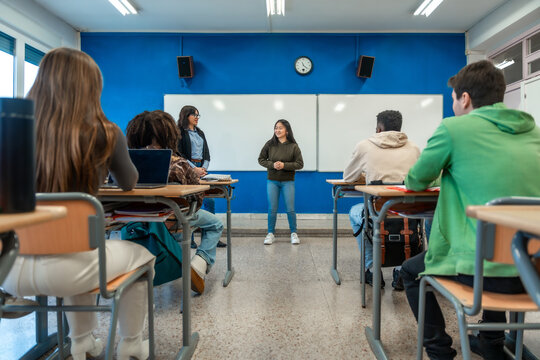High school student giving presentation to classmates and teacher