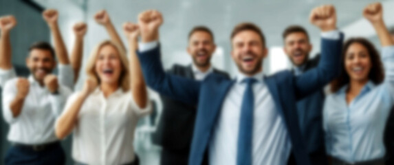 Obraz premium Blurred background revealing a group of colleagues in a modern office environment, fists pumping in excitement