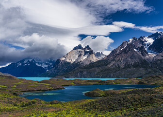 Dramatic clouds over mountains near turquoise and clear blue waters in Patagonia