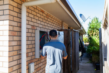 Electrician tradesman working on outside breaker box power box