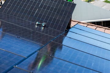 Drill laying on all Black bifacial solar panels on roof during solar system installation