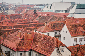 Scenic aerial view of historic European rooftops covered with red clay tiles and chimneys. Old town...