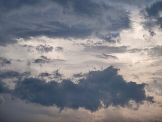 Obraz premium An evening sky layered with heavy clouds, as the last traces of sunlight fade into the horizon.