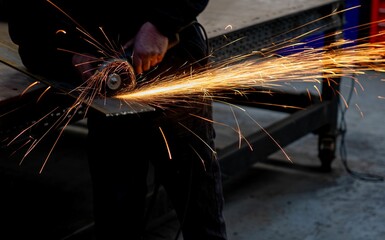 Worker using angle grinder creating sparks