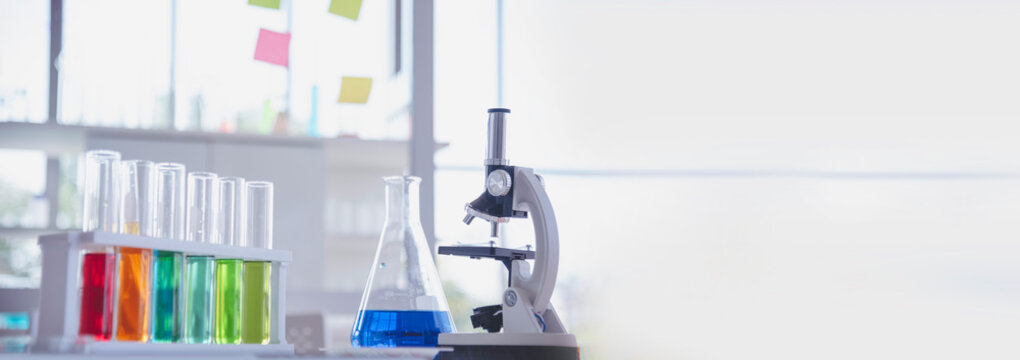 Banner Science laboratory chemistry test science lab with microscope glass tubes chemical beaker scientific background. Colorful Liquid biology laboratory fluid scientist experiment with copy space